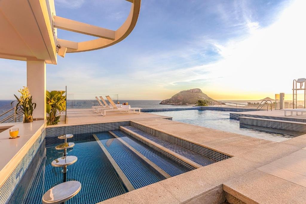 CDesign hotel no rio de janeiro com bar molhado e piscina em área elevada, de onde se tem vista privilegiada para uma das praias da cidade